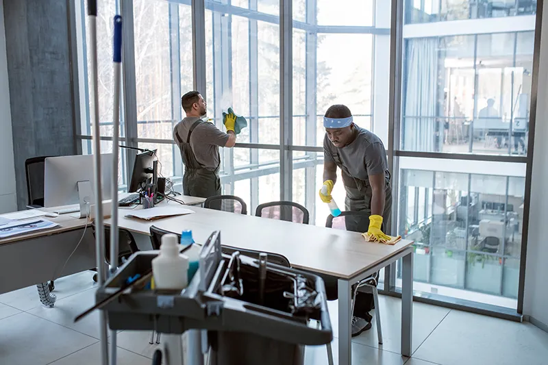 Glasreinigung Mörfelden-Walldorf, zwei Angestellter der Glebe Gebäudereinigungsfirma reinigen einen Meetingraum und putzen die Glaswände, man sieht einen professionellen Reinigungswagen